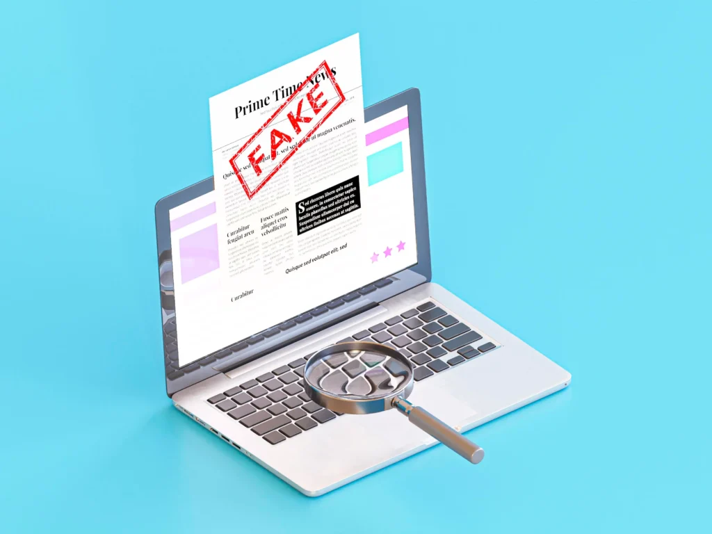 Laptop screen showing a fake website warning with a magnifying glass inspecting it