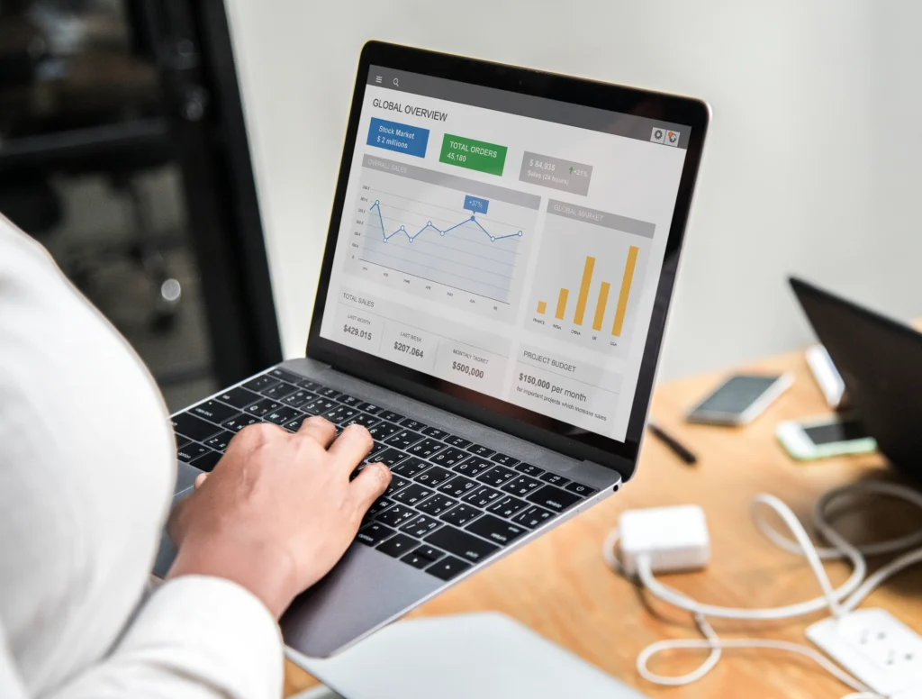 Laptop showing website performance analytics from affordable web design services with growing traffic and sales charts